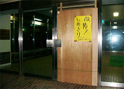 2日の強風で割れた正面玄関のガラスをベニヤ板でふさいで応急処置した三条市体育文化センター