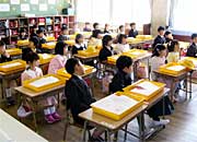 教室で担任の話を聞く1年生
