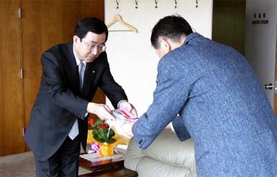 カーブミラーの目録を高橋三条市長(右)に手渡す杉野三条信用金庫理事長(左)