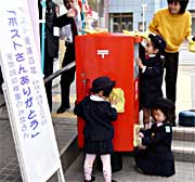 真っ赤なポストを一生懸命に掃除する園児