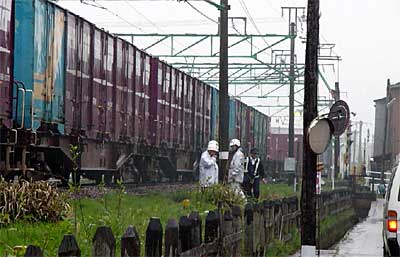 男性をはねた貨物列車と、はねられた現場を捜査する三条署員
