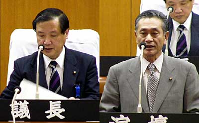 新三条市議会初代議長となって議長席につく久住市議(左)、副議長に決まってあいさつする木菱市議(右)