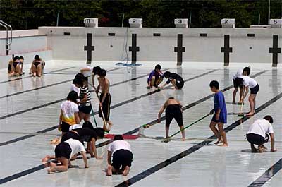 三条市民プールで強化練習する三条市内の民間スイミングスクール所属の中学生と高校生の水泳部員が清掃ボランティア