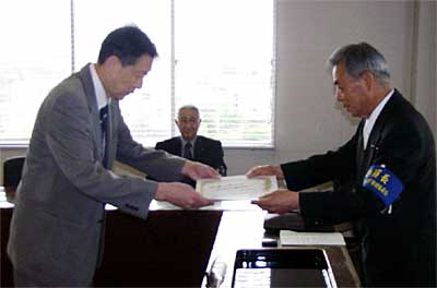 長沼三条市選挙管理委員会委員長(右)から市長選当選証書を受け取る高橋氏(左)
