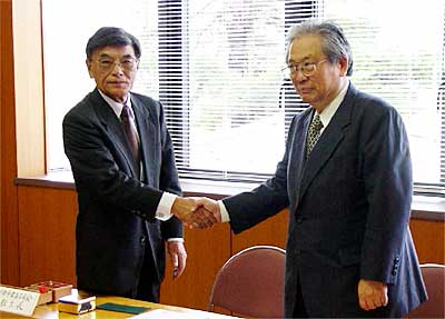 調印後、握手する生田新潟大学教育人間科学部長(右)と松永三条市教育長(左)