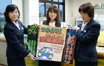 冬の交通事故防止運動用のポスターを手に燕市交通安全協会職員