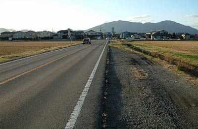 11日、日差しで路面が乾いた弥彦山に向かって延びる燕市内の国道289号