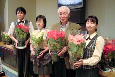 25日に抽選で来館者にプレゼントするポインセチアの鉢植えを手に「いい湯らてい」の佐藤社長(右から2人目)と従業員