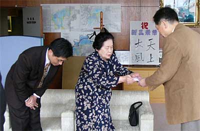 左から故杉野奎司さんんの長男真司さん、妻美智子さん、高橋三条市長