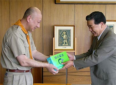 小林燕市長(右)に緑の募金の募金箱を手渡す黒田ボーイスカウト燕第1団団長(左)