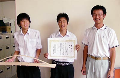 左からサポートの優勝した橋梁模型を手にサポートの梅田さん、優勝の表彰状を手に佐藤さん、渡辺教諭