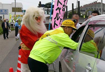 26日、燕市交通安全対策協議会が国道116号で行った交通安全特別街頭指導、鬼姿の酒呑童子とドライバーにちらしなどを手渡す小林燕市長