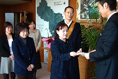 国定三条市長に善意を手渡すきらきら保育園の遠藤園長ら