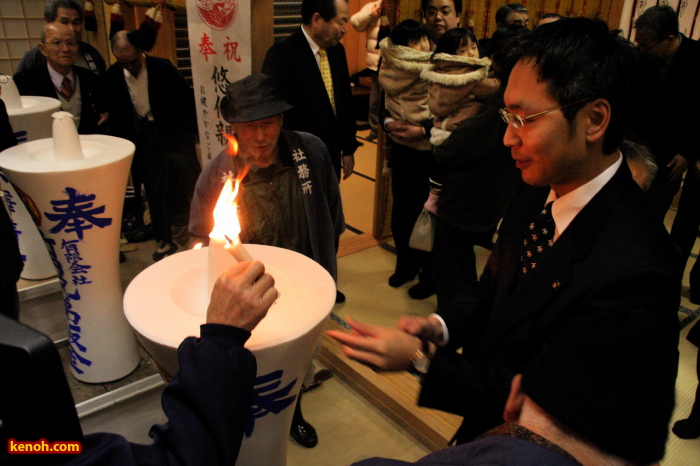 皮切りに御神火をろうそくにともす国定三条市長 