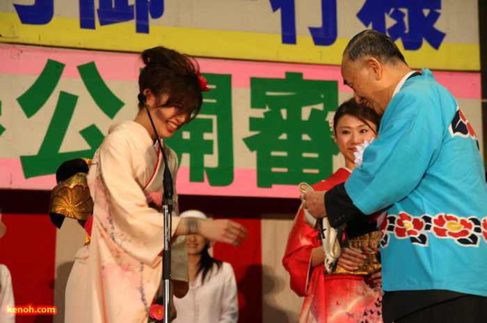 小池加茂市長からたすきを受けるミス雪椿クイーンの吉崎さん