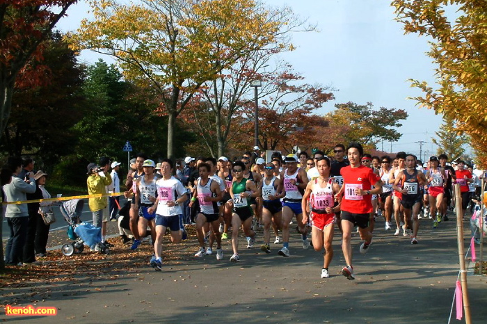 紅葉の街路樹のなか、いっせいにスタートするランナー