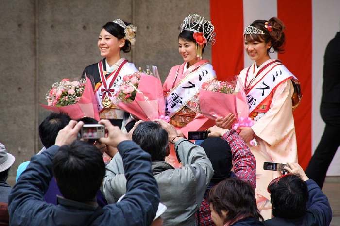 市民の写真の撮影にこたえるミス雪椿3人