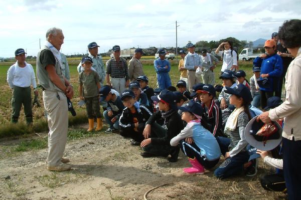 安達組合長から田んぼの説明などを聞く