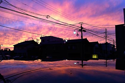 三条市本町5の大通りから見た24日の夕焼け空、下に映る夕焼けは車のルーフ