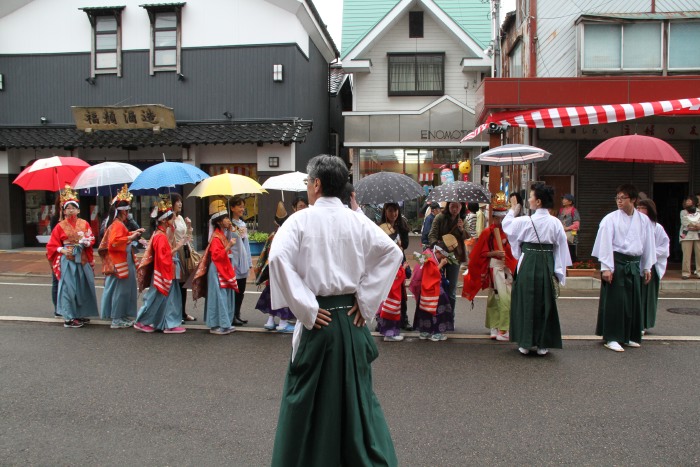 雨が強まって稚児に傘を差す