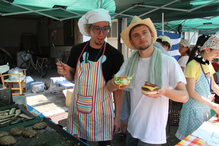 三条市国際交流員のピーターさん（左）はALTのトムさん（右）とハンバーガーを調理
