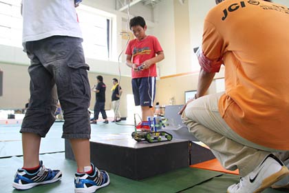 ロボットの操作に集中、熱中する小学生