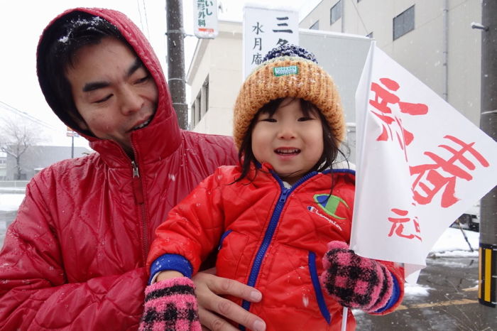 沿道で応援にする人に初めて配った「新春　三条市元旦マラソン大会」小旗、名古屋豊市議も親子で小旗を手に応援