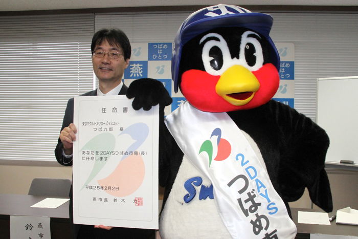 巨大な任命書を掲げてつば九郎と鈴木市長で記念写真