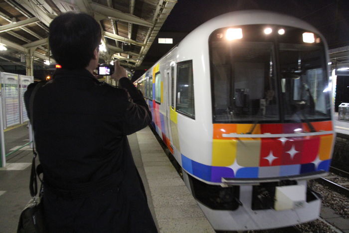 吉田駅のホームに滑り込む快速「きらきらうえつ」を撮影する鈴木燕市長