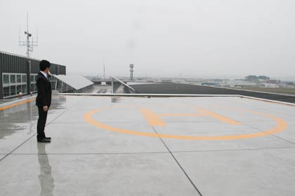 市の公共施設では初めての屋上ヘリポート、その向こうに太陽光パネル