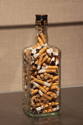 ウイスキーの空き瓶に吸い殻を詰めた「酒とたばこ」