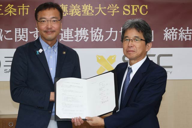  「地方創生に関する連携協力協定」に調印した国定市長(左)と慶応大SFCの総合政策学部の河添健学部長
