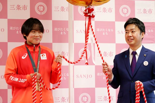 照れくさそうに滝沢市長とくす玉のひもを引く