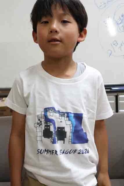 プレゼントされた坂井さんの作品がプリントされたTシャツを着た坂井さん