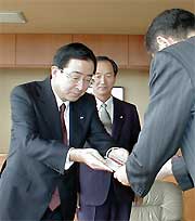 故金子六郎氏の遺族と三条信用金庫からの寄付を高橋一夫三条市長に手渡す金子俊郎三条信用金庫常務理事