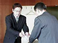 寄付を市長に手渡す居酒屋まんなかの山田達彦店長