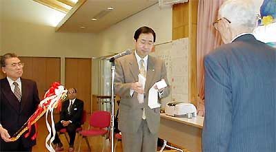 山岸六一理事長(右)に目録を手渡す金子俊郎三条信用金庫常務理事