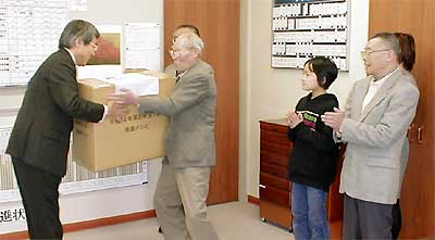大きな段ボール箱に入った賞品を手に感激の当選者