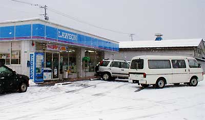 強盗に遭ったコンビニ店、右の白い車2台は三条署の鑑識