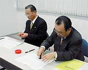 調印する佐藤田上町長(左)と高橋燕市長