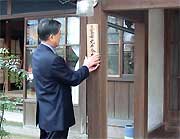玄関前の柱に表札を掲げる高橋市長