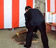 クワ入れする高橋市長