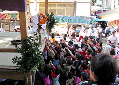 五穀散の舞で怜人が投げる菓子に群がる子どもたち