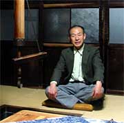 囲炉裏の前で話す鶴巻嶺二さん