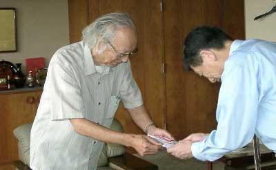 高橋三条市長に寄付を手渡す栗山繁さん