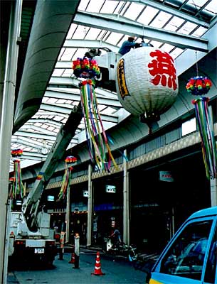 燕サンロード宮町商店街にお目見えした大ちょうちんは、作業する人と比べるとその巨大さがよくわかる