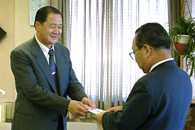 高橋燕市長（右）に5万円を手渡す花園いさみ鮨の谷口代表（左）