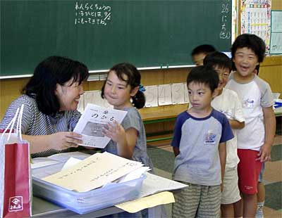 担任から初めての通知表を受け取る燕西小学校1年生