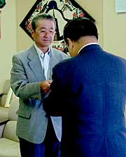 高橋燕市長（右）に寄付を手渡す宇佐美貢二燕市民ゴルフ大会実行委員会会長（左）