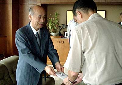 高橋三条市長（右）に寄付の目録を手渡す内田(株)コロナ社長（左）